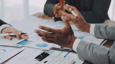 Genç girişimciler, iş ve finans kavramlarını somutlaştıran çağdaş bir ofiste birlikte çalışıyorlar..