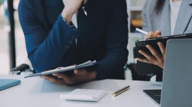 Genç girişimciler, iş ve finansman odaklı modern bir ofis alanında birlikte çalışıyorlar.