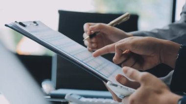 Genç girişimciler, iş ve finansman odaklı modern bir ofis alanında birlikte çalışıyorlar.