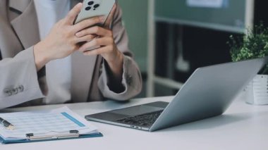 Modern ofis ortamında çalışan Asyalı profesyonel iş kadını.