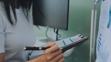 Modern ofis ortamında çalışan Asyalı profesyonel iş kadını.