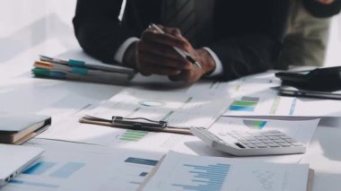 Çağdaş bir ofis ortamında işbirliği yapan genç profesyonellerden oluşan bir ekip, iş ve finans temasını yansıtıyor