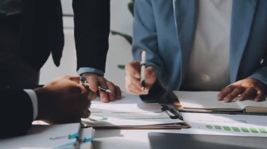 Modern bir ofiste iş ve finans odaklı bir grup genç profesyonel.