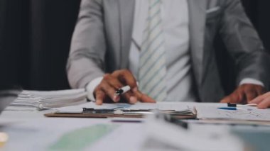 İş ve finans merkezli, modern bir çalışma alanında işbirliği yapan bir grup genç iş adamı.