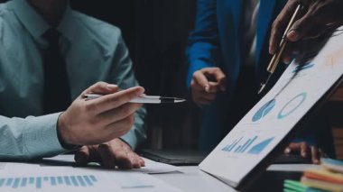 Modern ofis ortamında iş ve finans konularına odaklanan genç iş adamlarından oluşan bir ekip.
