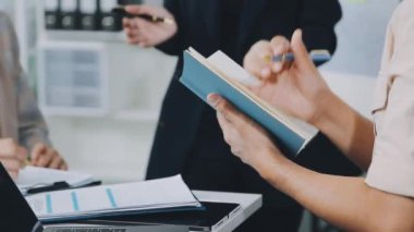 Çağdaş bir ofis ortamında iş birliği yapan bir grup hırslı genç iş adamı, finansal kavramları yansıtıyor..