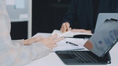 Çağdaş bir ofis ortamında iş birliği yapan bir grup hırslı genç iş adamı, finansal kavramları yansıtıyor..