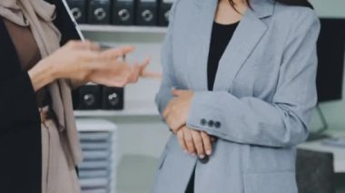 İki iş kadını ofiste el sıkışıyor.