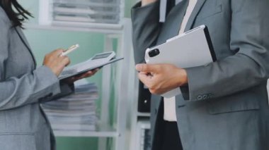 Enerjik genç iş uzmanlarından oluşan bir grup, yenilikçi finansal stratejiler geliştirmeye ve sergilemeye odaklanarak, modern bir ofis ortamında aktif olarak işbirliği yapmaktadır..