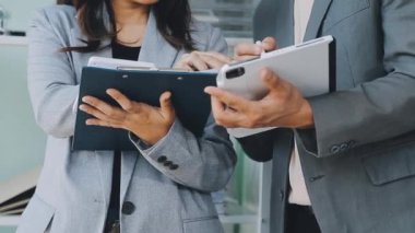 Enerjik genç iş uzmanlarından oluşan bir grup, yenilikçi finansal stratejiler geliştirmeye ve sergilemeye odaklanarak, modern bir ofis ortamında aktif olarak işbirliği yapmaktadır..