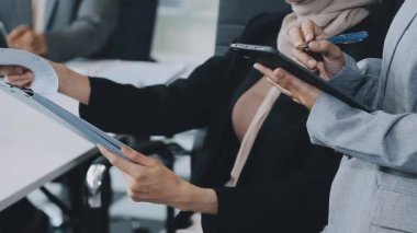 Enerjik genç iş uzmanlarından oluşan bir grup, yenilikçi finansal stratejiler geliştirmeye ve sergilemeye odaklanarak, modern bir ofis ortamında aktif olarak işbirliği yapmaktadır..