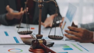 Bir grup hukukçu, modern ofis ortamındaki bir sözleşme anlaşmasını inceliyor.