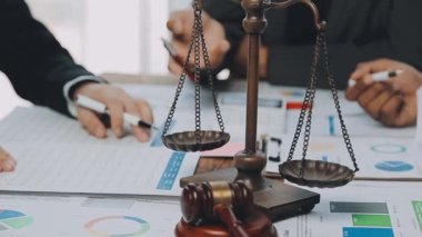 Bir grup hukukçu, modern ofis ortamındaki bir sözleşme anlaşmasını inceliyor.