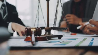 Bir grup hukukçu, modern ofis ortamındaki bir sözleşme anlaşmasını inceliyor.