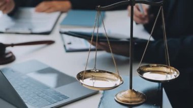Bir grup hukukçu, modern ofis ortamındaki bir sözleşme anlaşmasını inceliyor.
