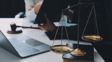 Bir grup hukukçu, modern ofis ortamındaki bir sözleşme anlaşmasını inceliyor.