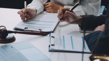 Bir grup hukukçu, modern ofis ortamındaki bir sözleşme anlaşmasını inceliyor.