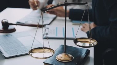 Bir grup hukukçu, modern ofis ortamındaki bir sözleşme anlaşmasını inceliyor.