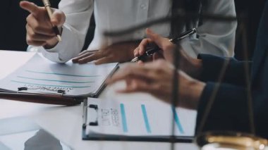 Bir grup hukukçu, modern ofis ortamındaki bir sözleşme anlaşmasını inceliyor.