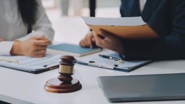 Bir grup hukukçu, modern ofis ortamındaki bir sözleşme anlaşmasını inceliyor.