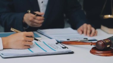 Bir grup hukukçu, modern ofis ortamındaki bir sözleşme anlaşmasını inceliyor.