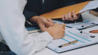 Bir grup hukukçu, modern ofis ortamındaki bir sözleşme anlaşmasını inceliyor.