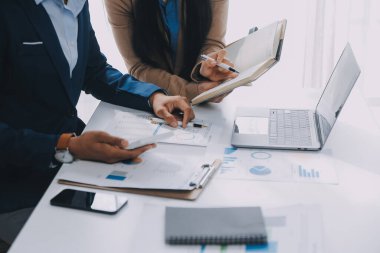 İş ekibi ile yeni başlangıç planı ve tartışma için proje bilgilerini dizüstü bilgisayar ve dijital tablet ile mali strateji bir modern iş salonda çalışıyor.