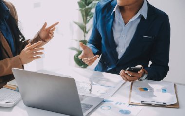 İş ekibi ile yeni başlangıç planı ve tartışma için proje bilgilerini dizüstü bilgisayar ve dijital tablet ile mali strateji bir modern iş salonda çalışıyor.