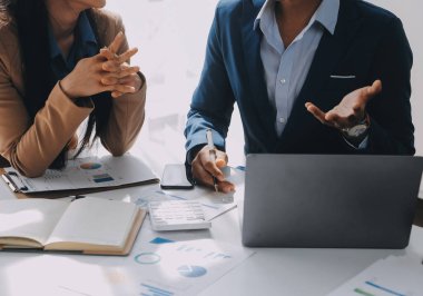 İş ekibi ile yeni başlangıç planı ve tartışma için proje bilgilerini dizüstü bilgisayar ve dijital tablet ile mali strateji bir modern iş salonda çalışıyor.