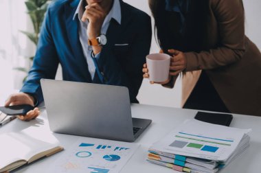 İş ekibi ile yeni başlangıç planı ve tartışma için proje bilgilerini dizüstü bilgisayar ve dijital tablet ile mali strateji bir modern iş salonda çalışıyor.