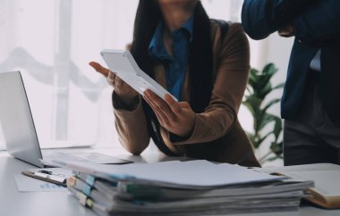 İş ekibi ile yeni başlangıç planı ve tartışma için proje bilgilerini dizüstü bilgisayar ve dijital tablet ile mali strateji bir modern iş salonda çalışıyor.