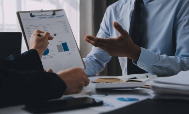 İş ekibi ile yeni başlangıç planı ve tartışma için proje bilgilerini dizüstü bilgisayar ve dijital tablet ile mali strateji bir modern iş salonda çalışıyor.