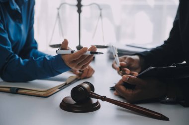 Adalet ve hukuk kavramı. Hukuk Müşaviri tokmak ve yasal hukuk veya yasal ile imzalanmış bir sözleşme istemciye sunar arka planda hukuk firmasında takım toplantısı