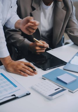 İş ekibi ile yeni başlangıç planı ve tartışma için proje bilgilerini dizüstü bilgisayar ve dijital tablet ile mali strateji bir modern iş salonda çalışıyor.