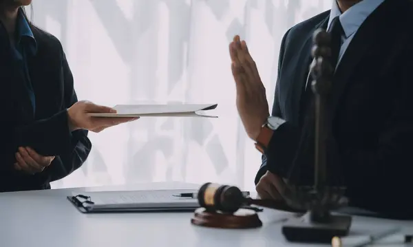 Adalet ve hukuk kavramı. Hukuk Müşaviri tokmak ve yasal hukuk veya yasal ile imzalanmış bir sözleşme istemciye sunar arka planda hukuk firmasında takım toplantısı