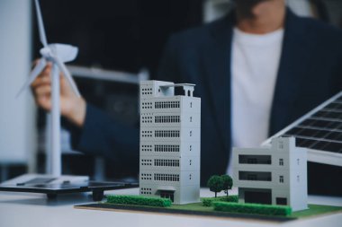 İki Genç Mühendis Güneş Hücresi Kurulum Toplantısı ve İş Tartışması Uzmanı. Ofis Odası 'nda Fabrika İnşaat Planlı Çatı Üzerine Güneş Fotovoltaik Panelleri Kurmayı Planlıyorum.