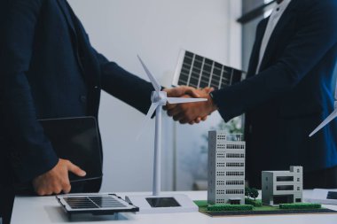 İki Genç Mühendis Güneş Hücresi Kurulum Toplantısı ve İş Tartışması Uzmanı. Ofis Odası 'nda Fabrika İnşaat Planlı Çatı Üzerine Güneş Fotovoltaik Panelleri Kurmayı Planlıyorum.