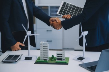 İki Genç Mühendis Güneş Hücresi Kurulum Toplantısı ve İş Tartışması Uzmanı. Ofis Odası 'nda Fabrika İnşaat Planlı Çatı Üzerine Güneş Fotovoltaik Panelleri Kurmayı Planlıyorum.