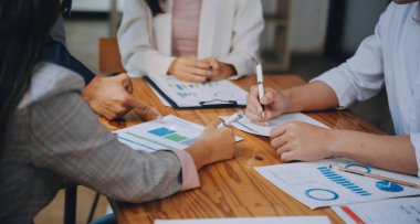 İş ekibi ile yeni başlangıç planı ve tartışma için proje bilgilerini dizüstü bilgisayar ve dijital tablet ile mali strateji bir modern iş salonda çalışıyor.