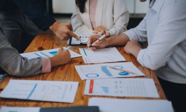 İş ekibi ile yeni başlangıç planı ve tartışma için proje bilgilerini dizüstü bilgisayar ve dijital tablet ile mali strateji bir modern iş salonda çalışıyor.