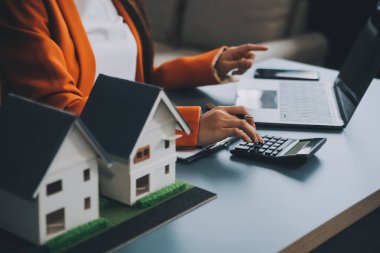 Emlakçı müşterilere örnek evler, ipotekli kredi sözleşmeleri veriyor. Kiralık bir ev alıp satmak için bir sözleşme yap. ve ev sigortası sözleşmeleri, ev kredisi konseptleri