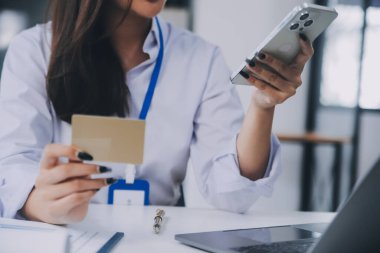 Evde kredi kartı tutan ve akıllı telefonlar kullanan kadınlar. Çevrimiçi alışveriş, internet bankacılığı, çevrimiçi mağaza, ödeme, harcama parası, e-ticaret ödemesi, kredi kartı, konsept