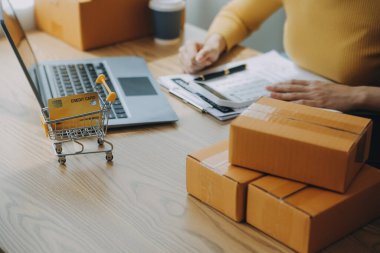 Genç bayan küçük işletme sahibi evden online alışveriş yapıyor. Cep telefonlu müşterilerden sipariş alıyordum. KOBİ girişimcisi veya serbest yaşam tarzı kavramı.