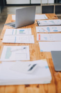 Bilgisayarı ve ahşap masasında akıllı telefonu olan bir ofis.