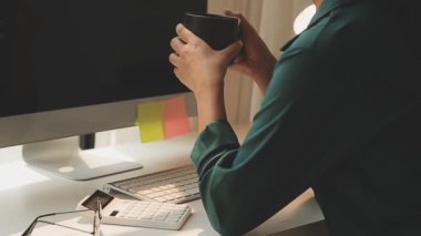 Genç Asyalı iş kadını modern ofis ortamında masa bilgisayarında çalışıyor.