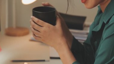 Genç Asyalı iş kadını modern ofis ortamında masa bilgisayarında çalışıyor.