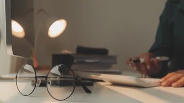 Ofiste hesap makinesi kullanan Asyalı işkadını mali rapor veya iş planı yatırımı, finans analizi kavramını analiz ederken.