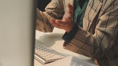 Genç Asyalı iş kadını modern ofis ortamında masa bilgisayarında çalışıyor.