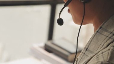 Genç Asyalı iş kadını modern ofis ortamında masa bilgisayarında çalışıyor.
