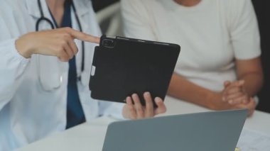 Doktor ve hasta bir tabletin sonuçlarını tartışıyor.